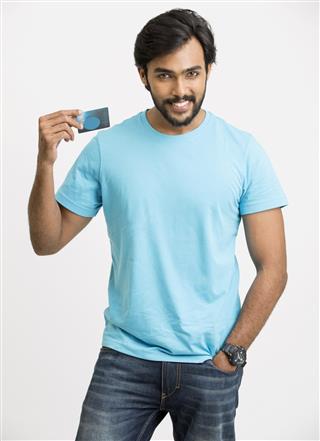 Cheerful young man holding a credit card