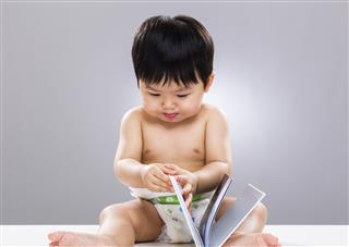 Chinese toddler looking at book