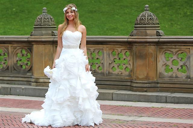 a bride wearing a white wedding gown with ruffles