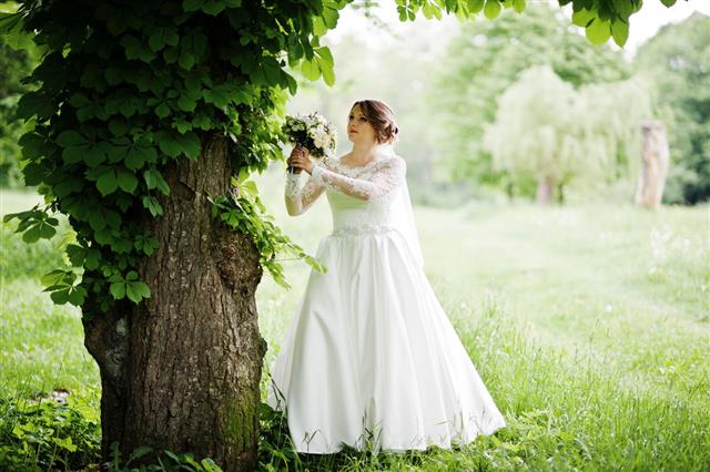 a bride wearing a long sleeve white wedding gown