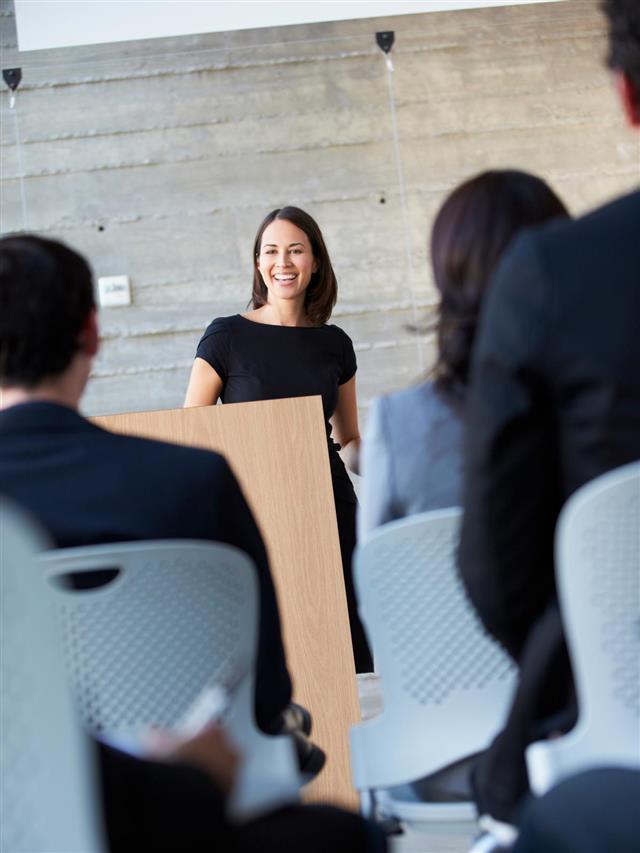 Smiling businesswoman delivers a presentation to an audience