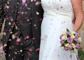 Photo of newly married couple, bride and groom with confetti