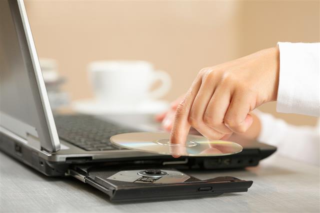 Woman's hand with laptop and compact disc