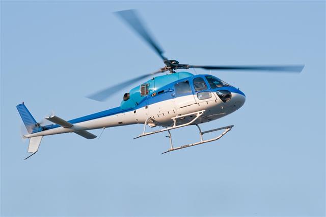 Flying helicopter in blue sky