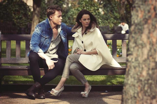 Young Caucasian couple sat on park