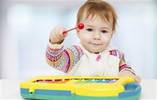 Child playing with toy xylophone