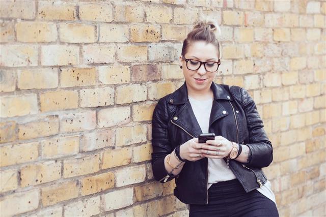 Hipster woman typing on smart phone