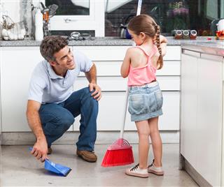 Father and daughter cleaning in the kitchen