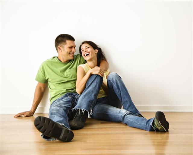 Laughing couple sitting on the floor