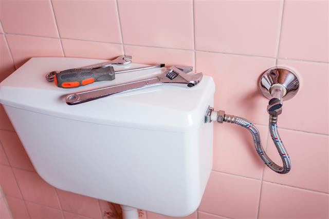 Plumbing tools lying on toilet