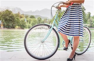 Beautiful woman dressed in fashion dress travel by vintage bicycle