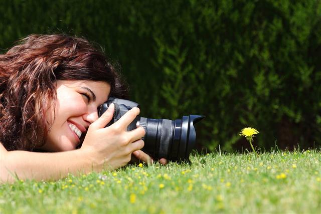 Woman taking photography of a flower