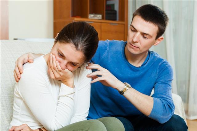 Crying woman has problem, man consoling her