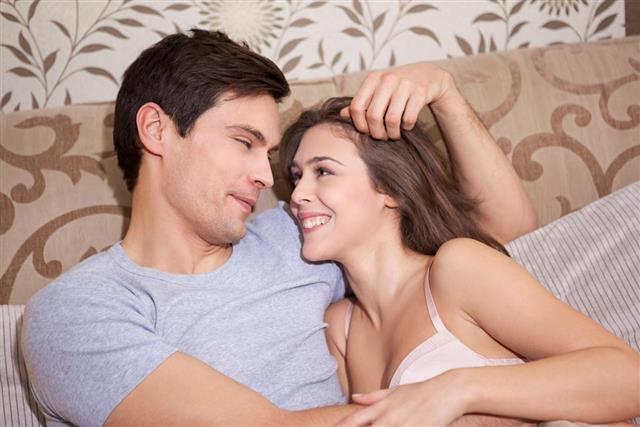 Happy young couple relaxing in bed