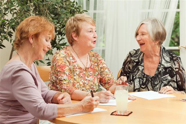 Happy Senior Women Doing Paper Work Together
