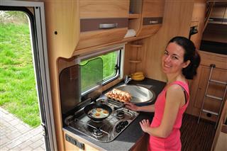Woman cooking in a camper