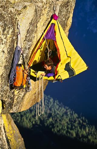 Rock climber in hanging tent