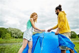 couple setting up tent outdoors