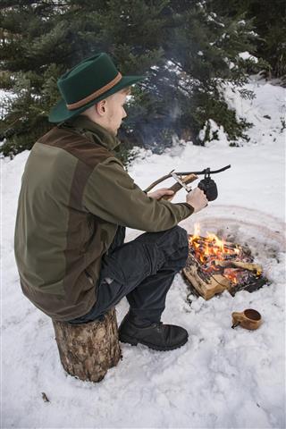 man sitting at campfire