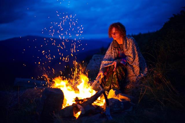 Woman by campfire