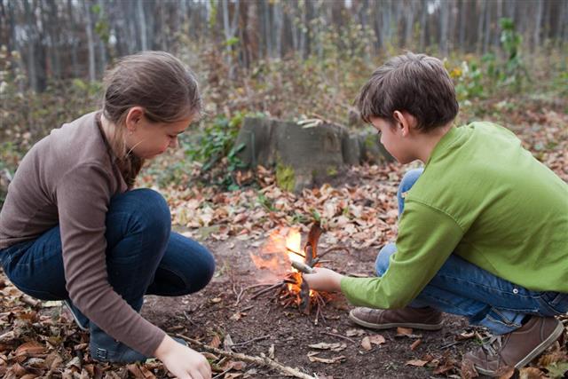 Children starting a campfire