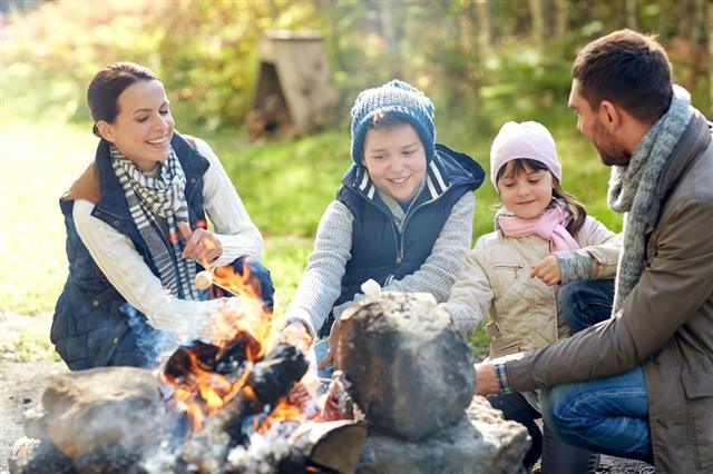 family roasting marshmallow over campfire
