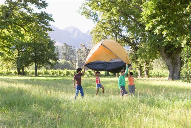 Adults carrying dome tent