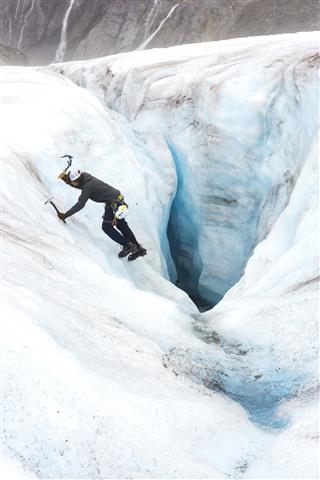 Ice Climber Descending A Crevasse