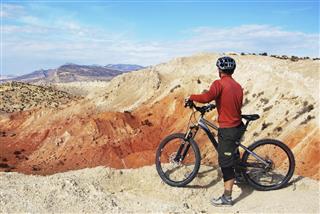 Mountain Biker Considering The Desert Landscape