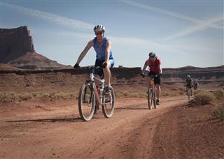 People Mountain Biking In The Desert