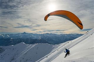 Paraglider Launching From Snowy Slope