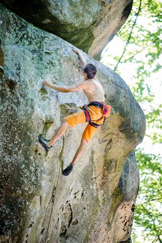 Male Rock Climber Climbing With Rope