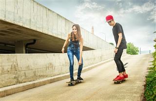Skateboarder couple rolling down