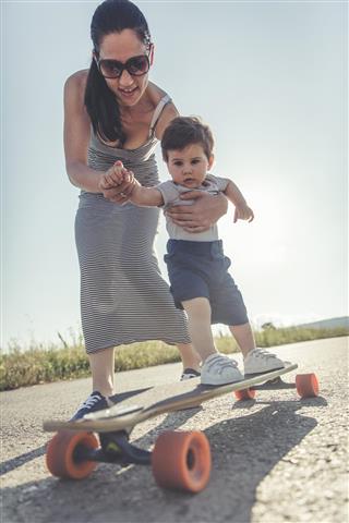 mom helping son to skateboard