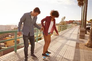 couple learning to skateboard