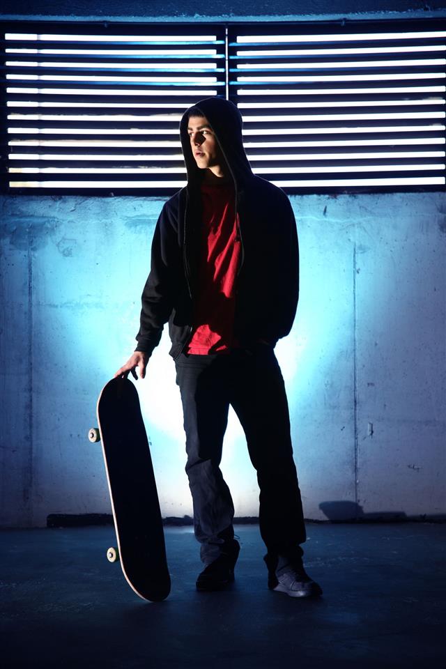 Teenager With Skateboard At Night