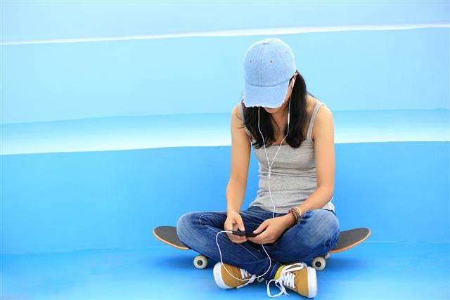 Woman skateboarder listening music