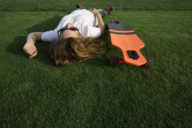 Girl on grass with longboard