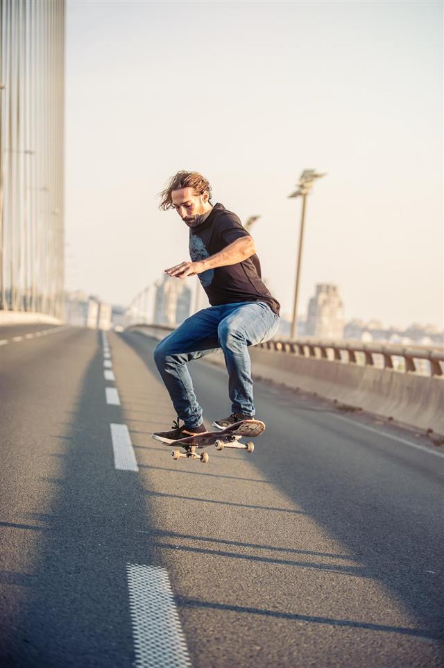 Skateboarder doing jump on the road