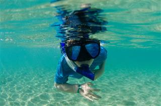 Child Snorkeling In Beautiful Water