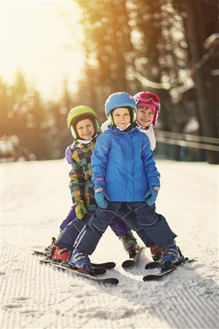 Kids Skiing On Sunny Winter Day