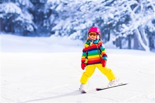 Little Girl Skiing In The Mountains