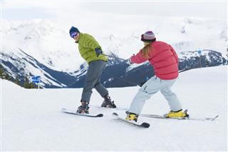Young Couple Skiing On Mountain Slope