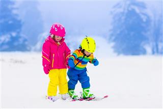 Children Skiing In Snowy Mountains