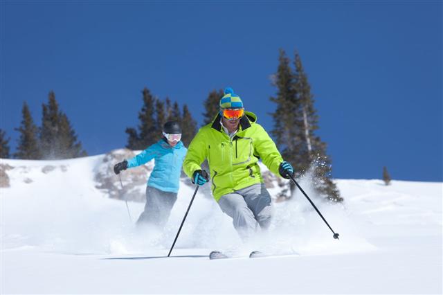 Couple Skiing In Fresh Powder Snow
