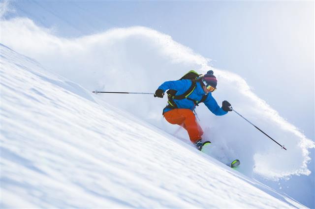 Female Athlete Skiing In Deep Powder