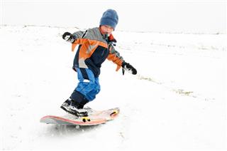 Young Boy Sleds Down Snow