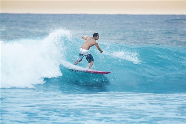 Surfer Surfing In Kauai Hawaii