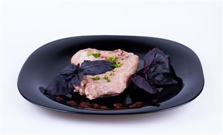Steak With Basil On Dark Plate