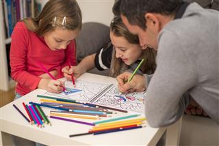 Children coloring picture with father